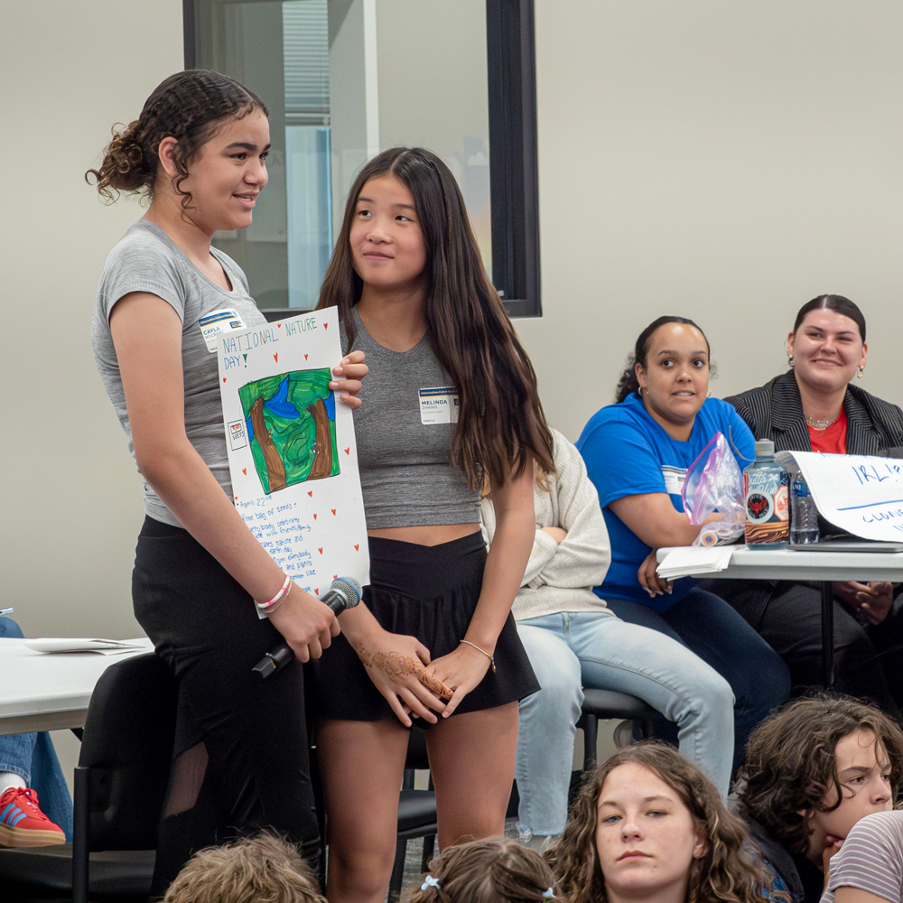 Two middle school girls presenting in front of the group