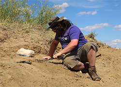 Kyle Atkins-Weltman, KU graduate assistant, digs at the Hell Creek Formation site.