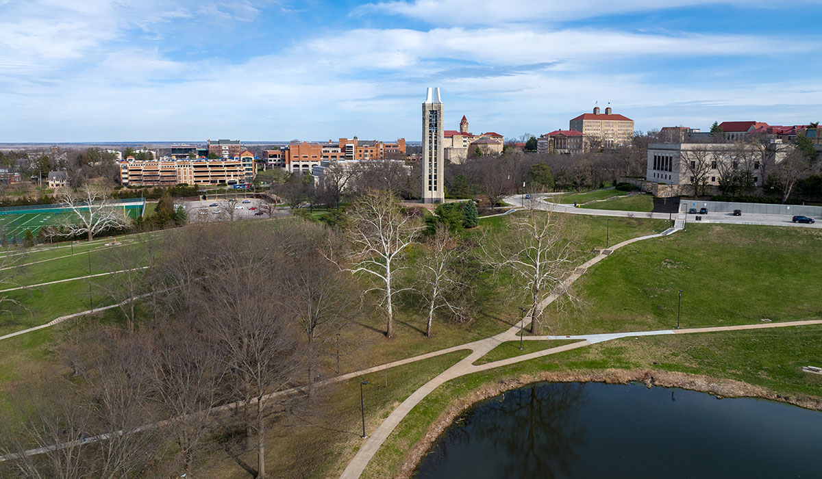Spring view of KU Lawrence campus with Potter Lake in foreground, budding trees,