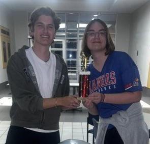 KU debaters Nate Boyle and Asra June holding trophies.