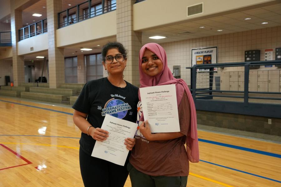 Fatima Noor Kharl and Diksha Chugh, two Jayhawk Fitness Challenge participants, holding scoresheets.