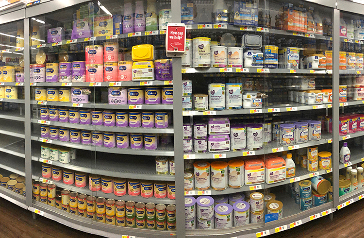 Shelves display cans of infant formula.