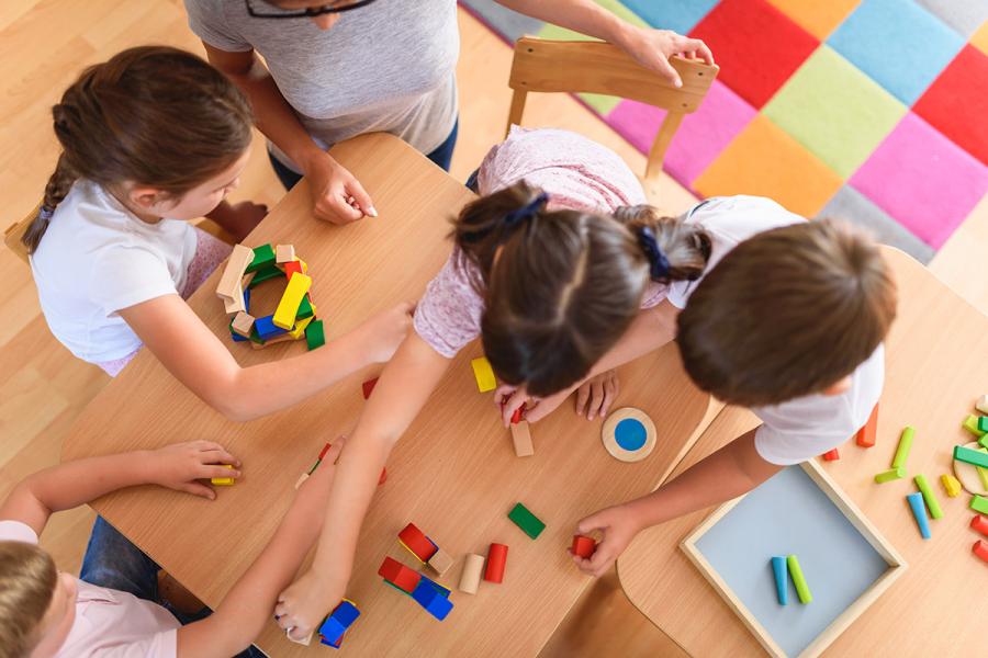 An overhead photo of a group of preschool students working on an art project.