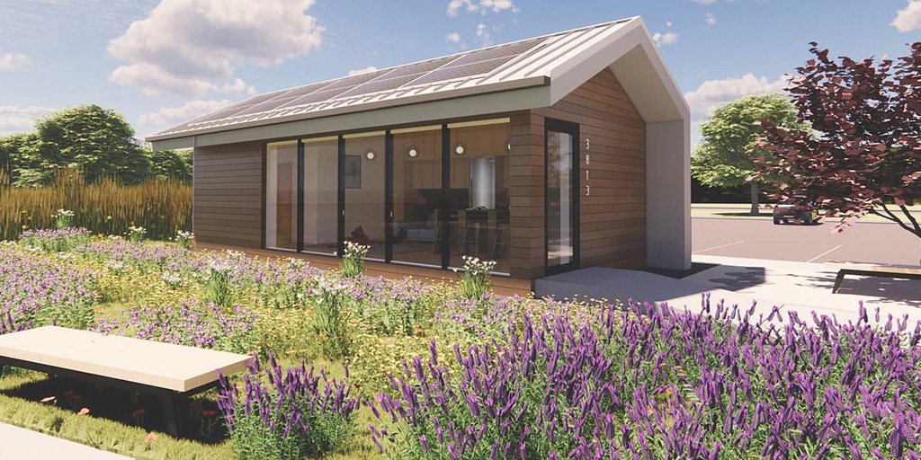 Digital rendering shows Haven Studio, a small wood-clad home with photovoltaic panels on roof, sited in a landscape of prairie plants in full bloom.