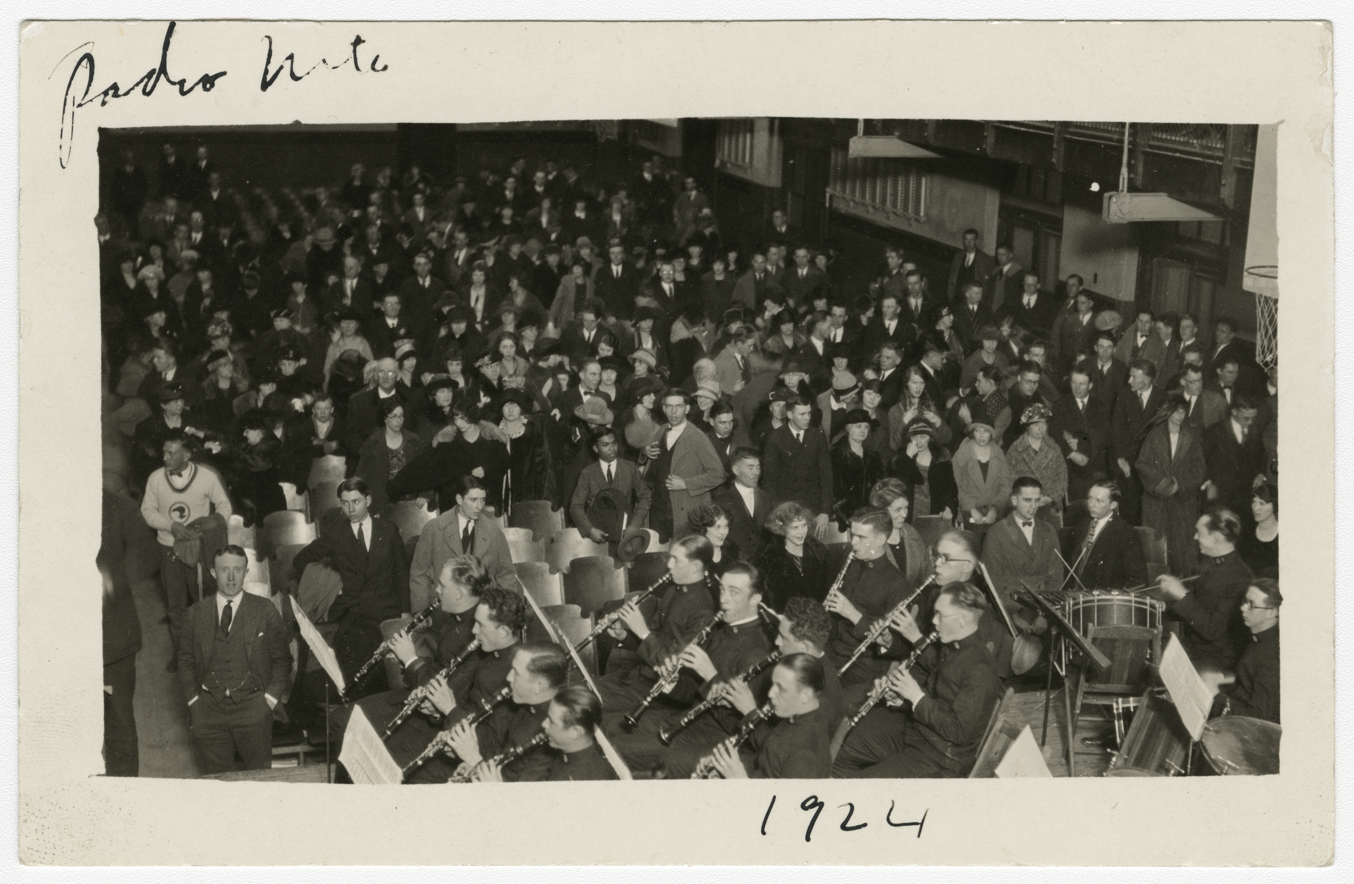 Photograph of an audience and orchestra at a Radio Music event in 1924, with people seated in rows and musicians positioned in the foreground.