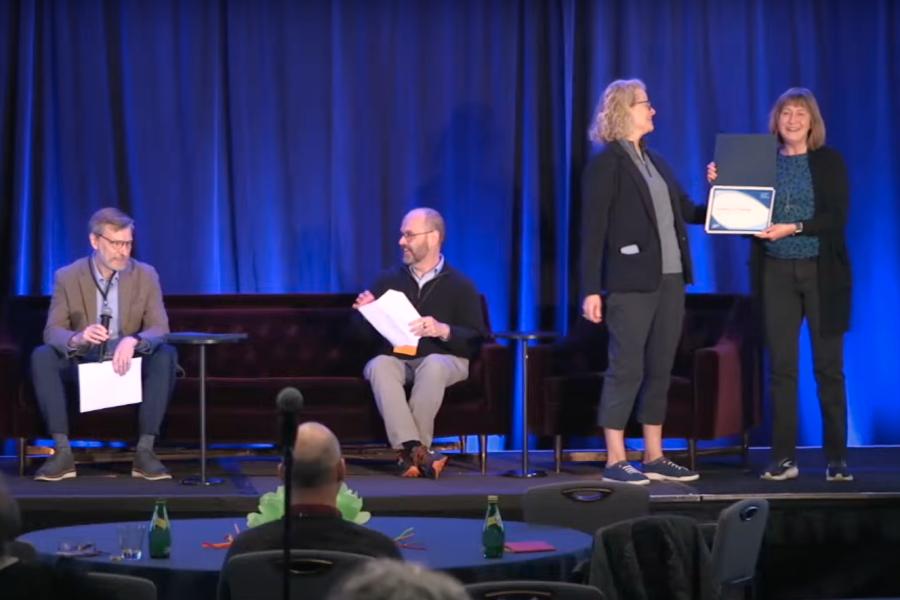 KU Libraries Dean Carol Smith receives a certificate on stage at the 10th Annual ARLIES.