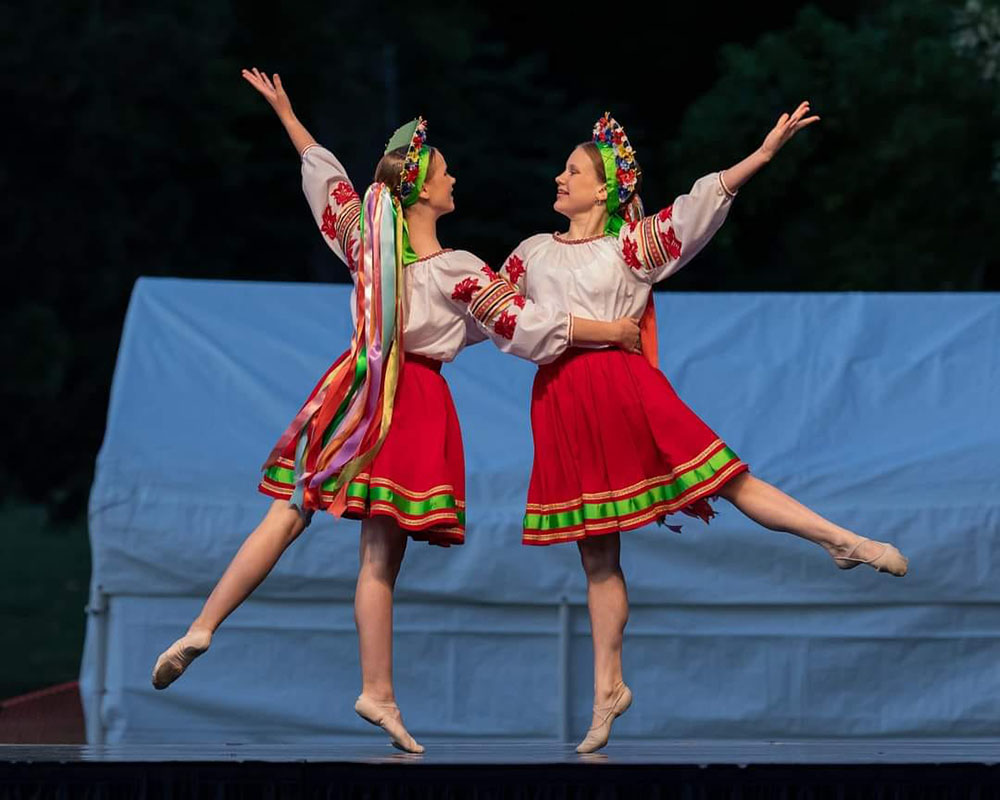 Pair of dancers in traditional costume of blouses and red skirts, part of Mayka, a Ukrainian dance company.