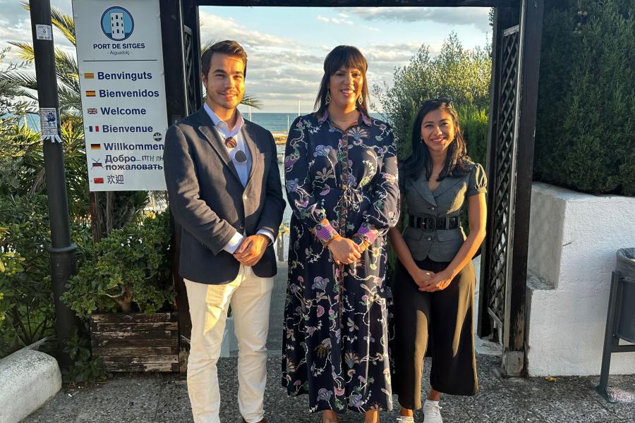 CARE researchers Dr. Kelsie Forbush, Robert William Morgan IV, and Sonakshi Negi pose in front of the Mediterranean Sea smiling.