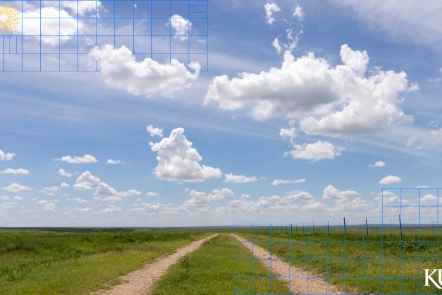 Scenic prairie land with gravel road, fence, and clouds