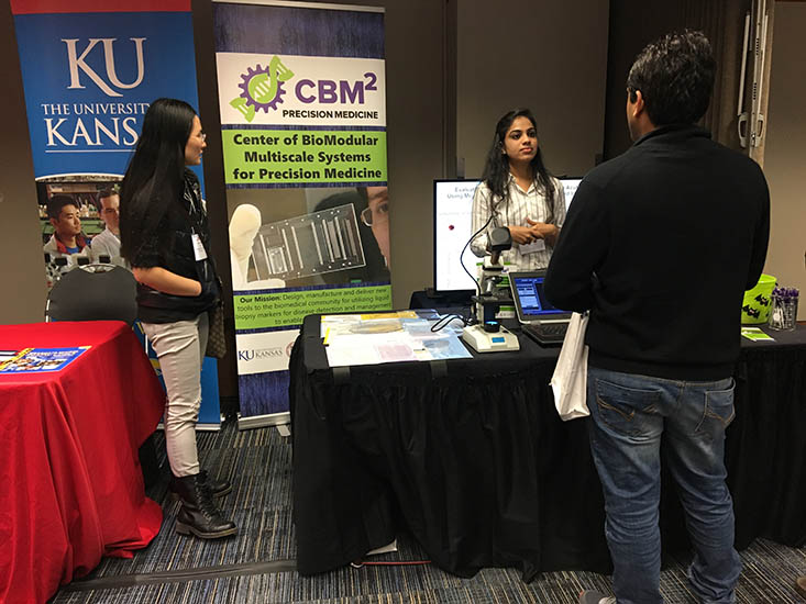 Wenting Hu and Swarnagowri Vaidyanathan discuss some of the projects the Center has with a visitor to the exhibitor booth.