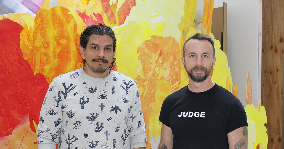 Co-curators and artistic collaborators Matthew Willie Garcia (left) and Shawn Bitters prepare “The Law for Falling Bodies:  A Queer Print Media Exhibition,” opening Nov. 18 at the Charlotte Street Foundation. Credit: Rick Hellman, KU News Service.