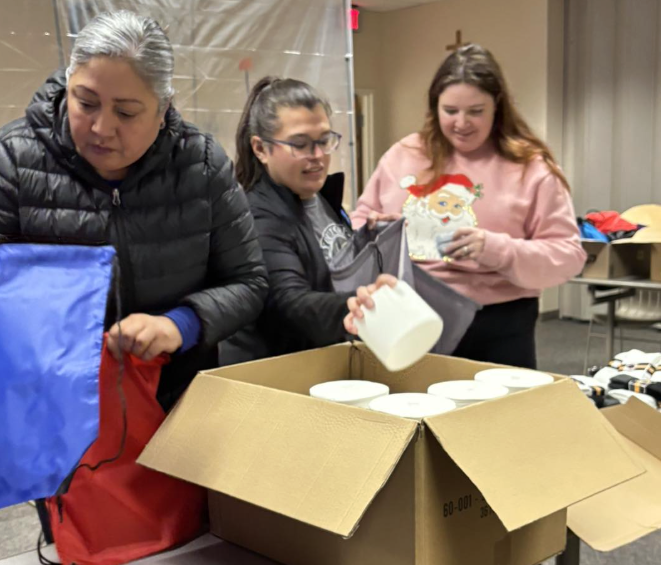 Three people put supplies in box