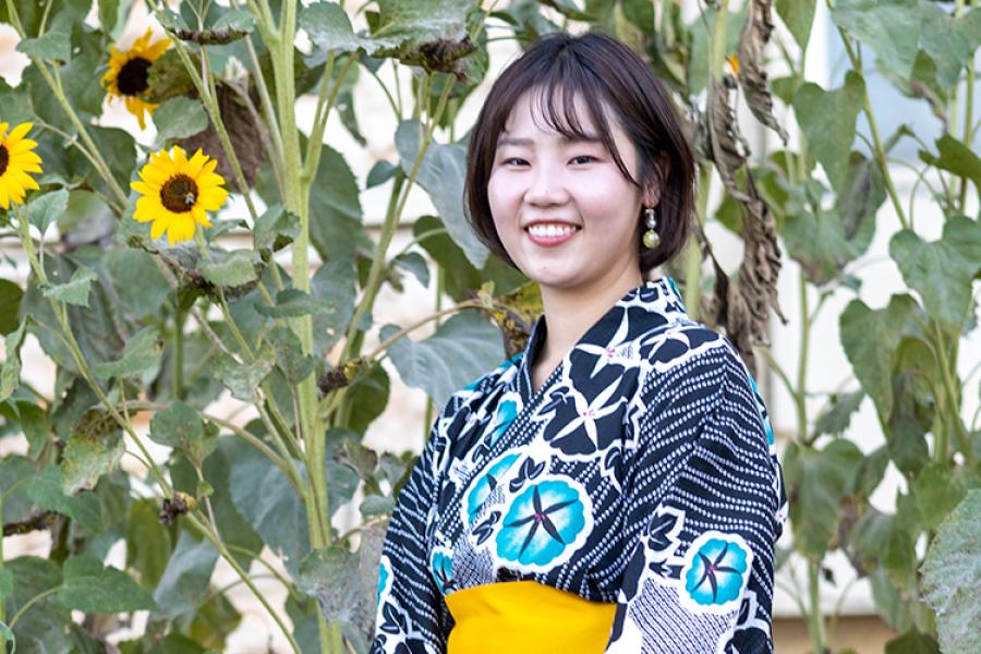 Miki Shono stands in front of sunflowers