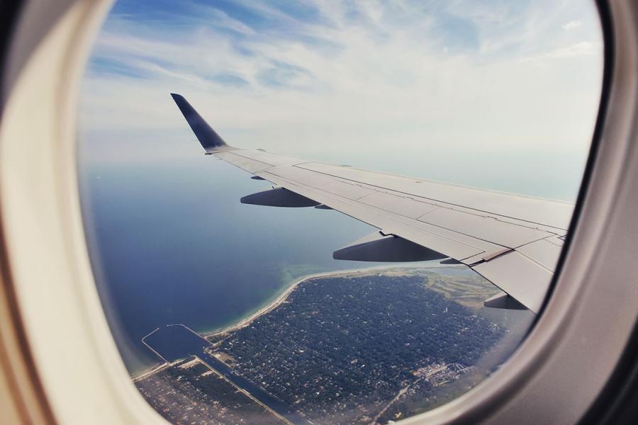 View out a plane window showing residential coastline, water.
