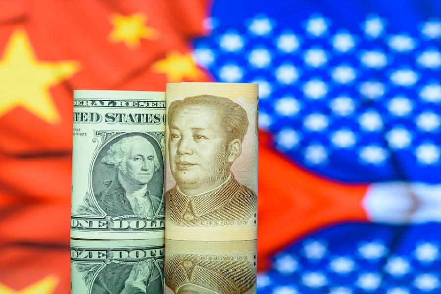 An American dollar and Chinese yuan are superimposed over a Chinese flag and American flag.