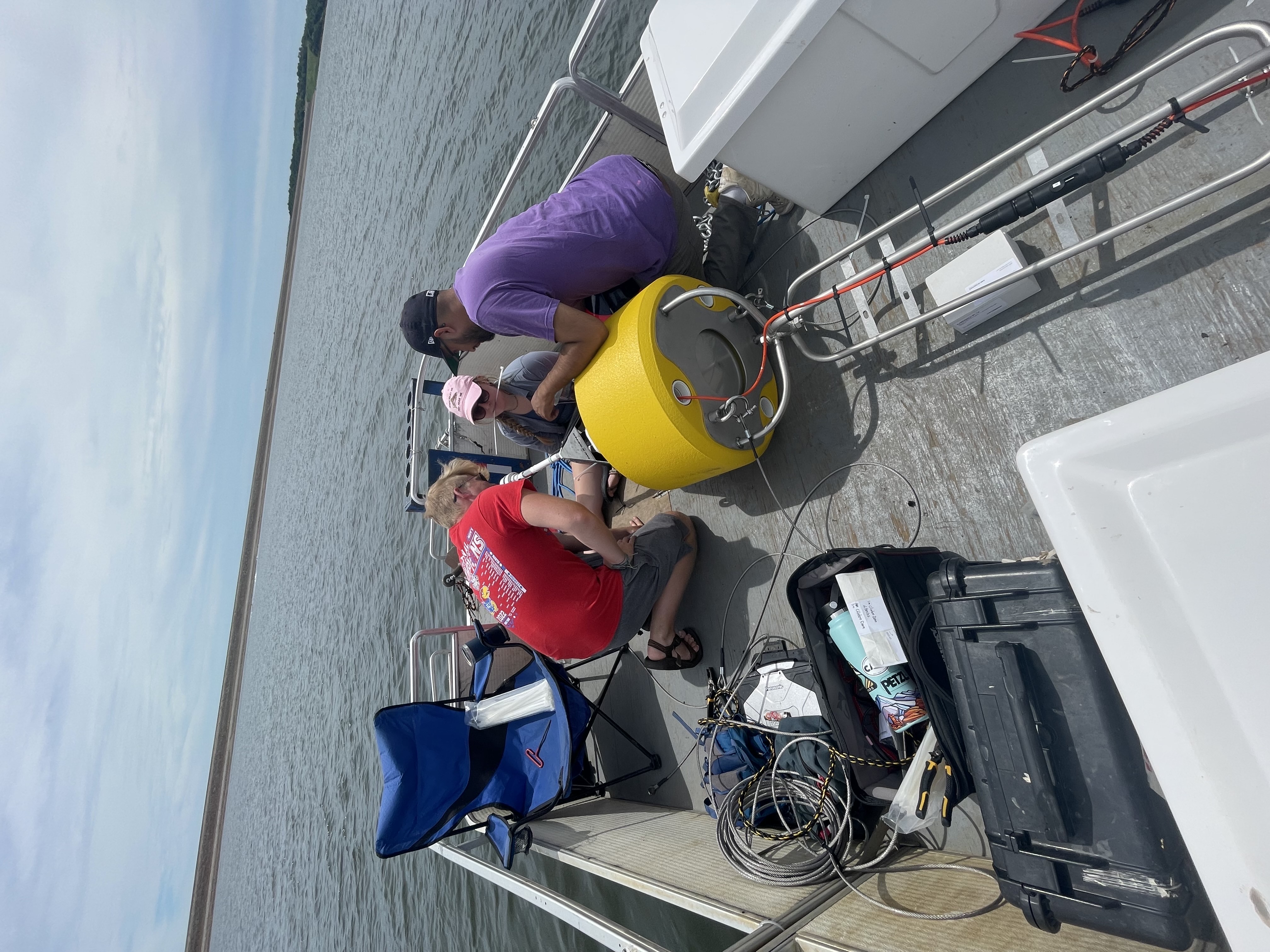 Adeline & two other researchers collecting data in a boat in the middle of a lake