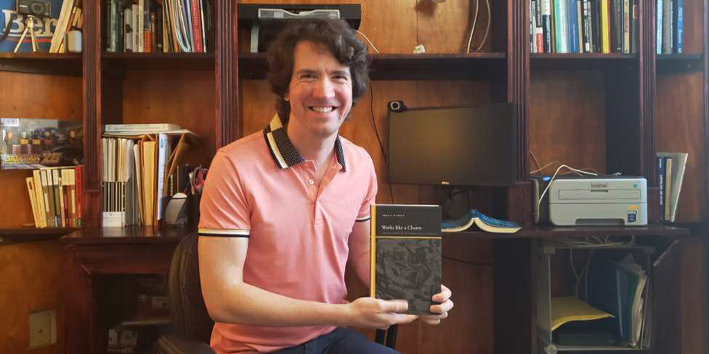 Robert McDonald, University of Kansas assistant professor of communication studies, with his new book, "Works Like a Charm: Incentive Rhetoric and the Economization of Everyday Life."