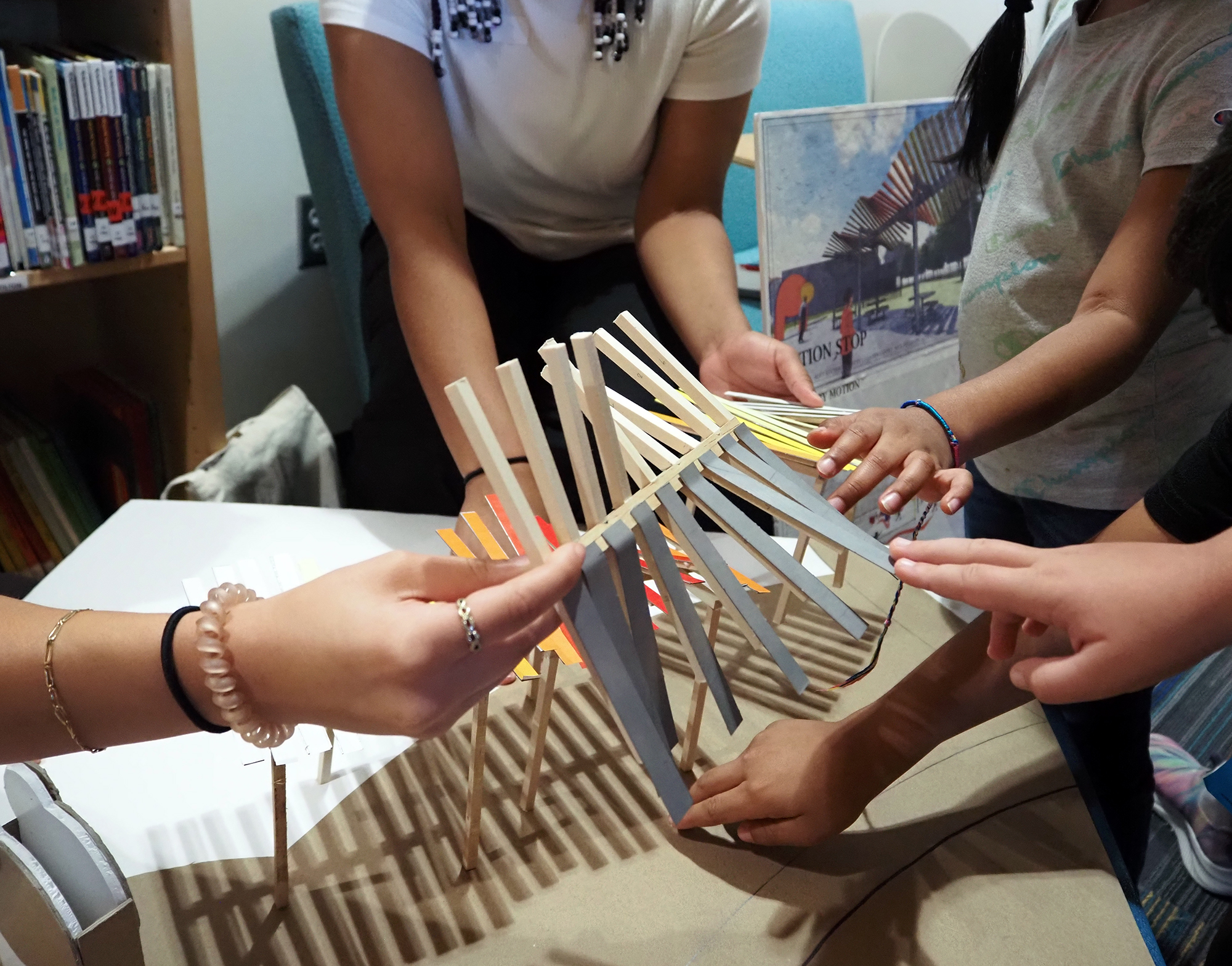 color photograph showing students examining architectural model.