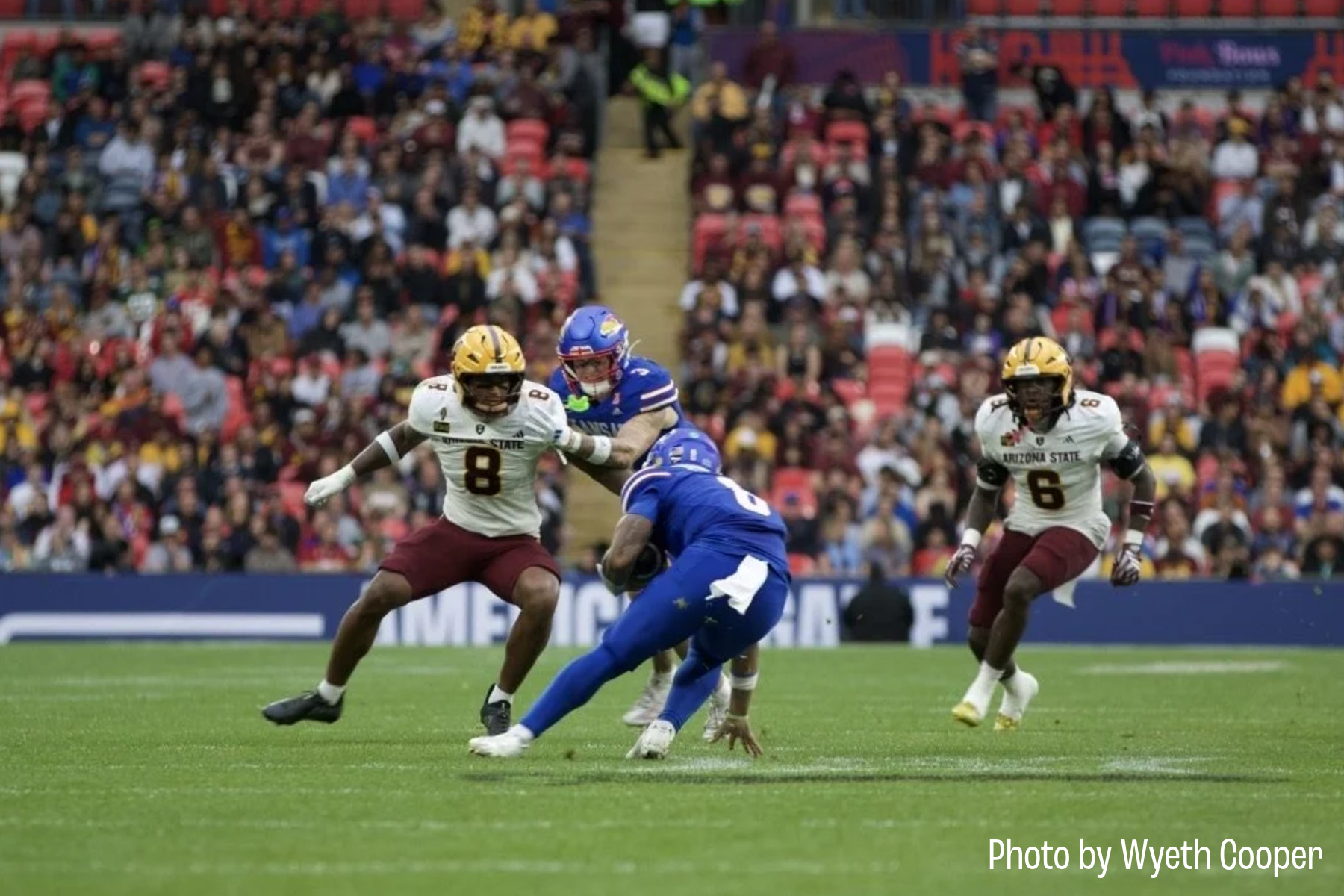 Kansas quarterback Isaiah Marshall attempts to evade a defender during Kansas' game against Arizona State in London on Sept. 19.