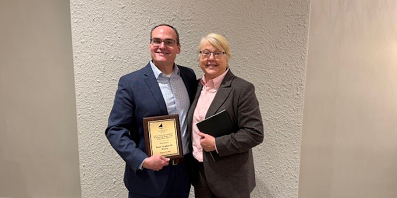 University of Kansas School of Law Dean Stephen Mazza poses with AALS President Kellye Testy while holding a plaque for his Excellence in Mentoring Future Legal Education Leaders Award